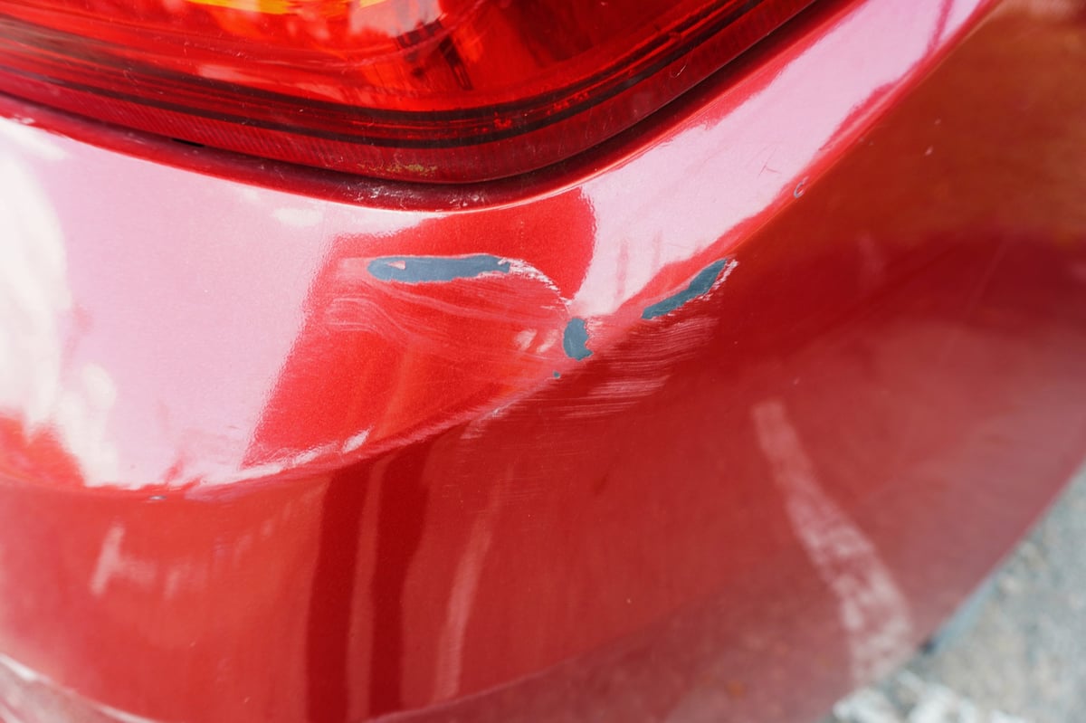 Rear bumper with deep scratches and scuff marks before repair
